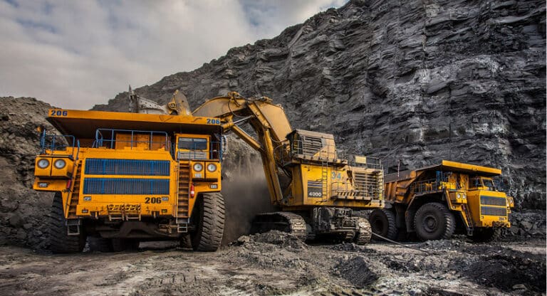 Mining & Metals Manufacturing Two large trucks parked side by side in a parking area.
