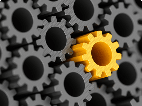 A group of interlocking gray gears with one prominent yellow gear positioned slightly above the rest.