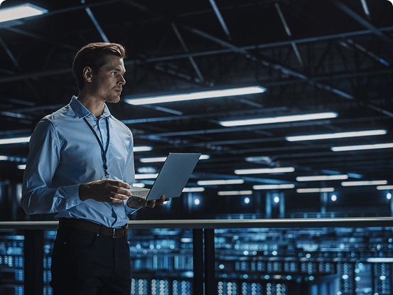 Two people working together at a computer in a dimly lit room with a futuristic background.