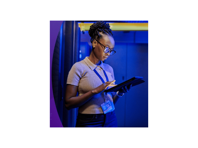 Person using a tablet in a blue-lit server room